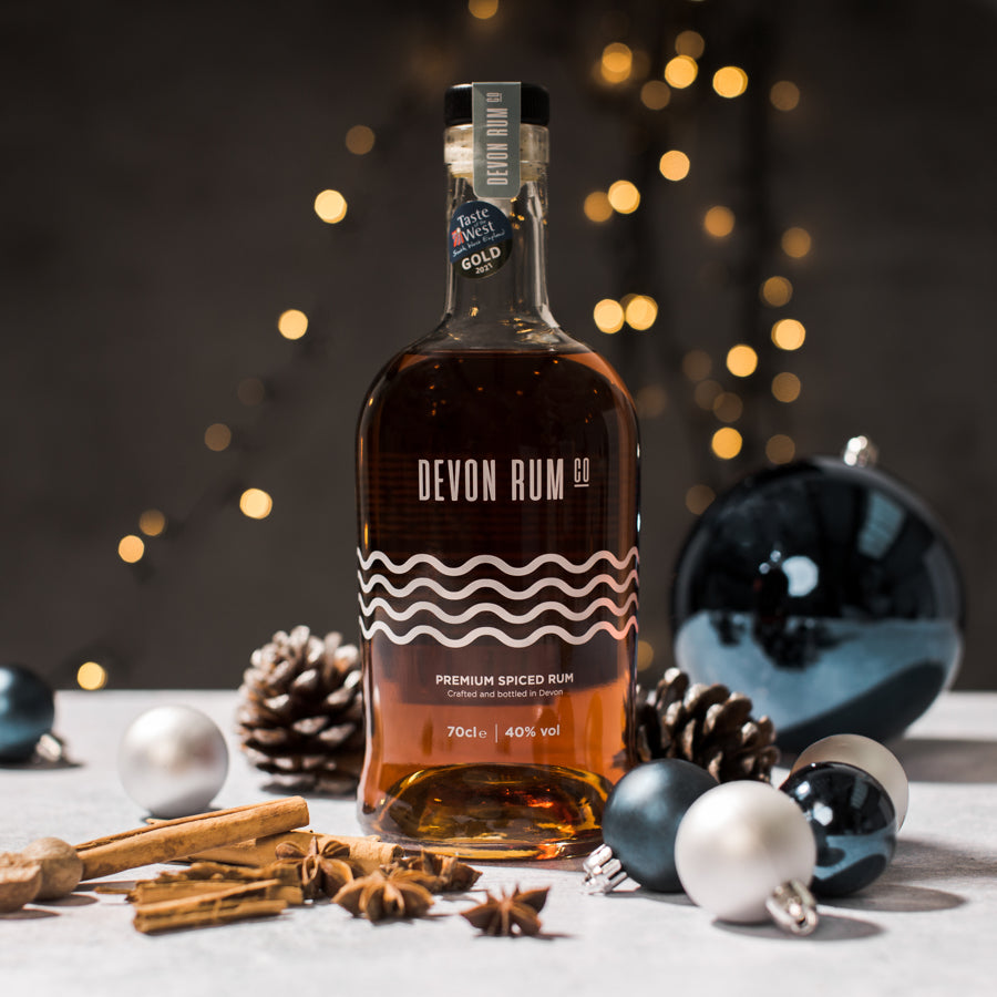 Devon Rum Co Premium Spiced Rum with baubles and festive setting. 