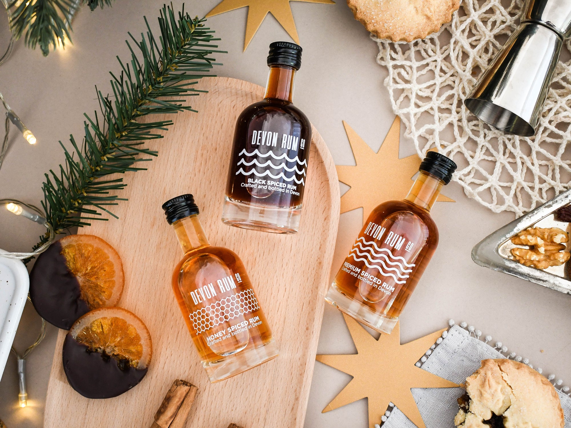 Devon Rum bottles on a wooden board with festive decorations