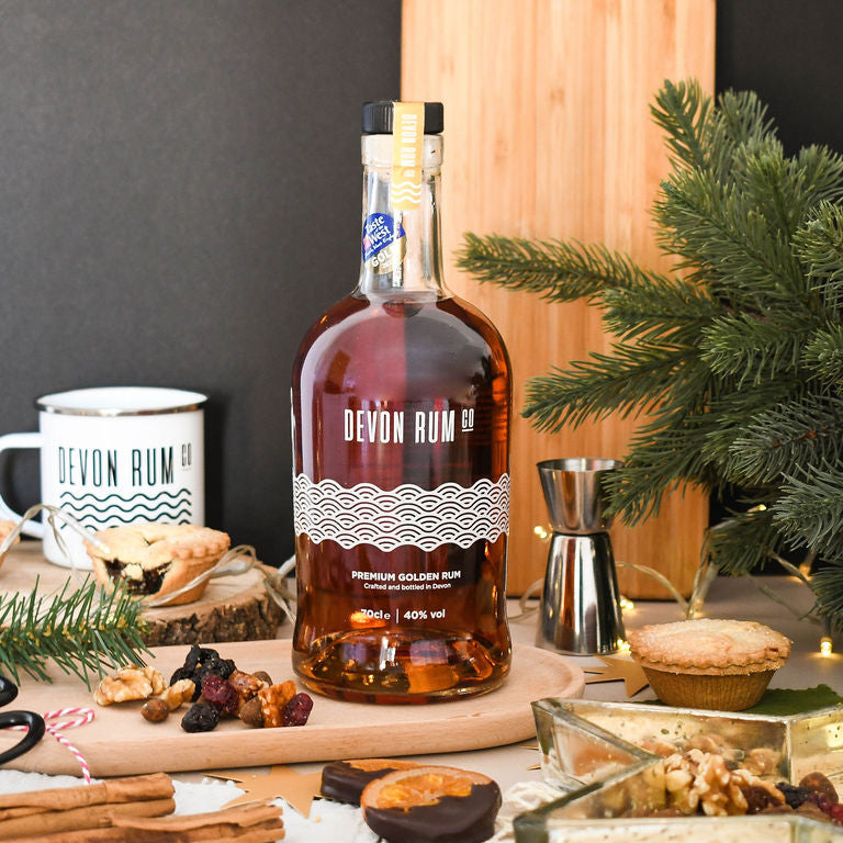 Devon Rum Co Premium Golden Rum in a festive setting with mince pies and dried fruits.
